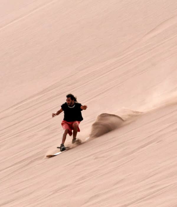 Sandboarding dans la vallée de la mort, en haut d une dune descendre sur le sable en surf board ski