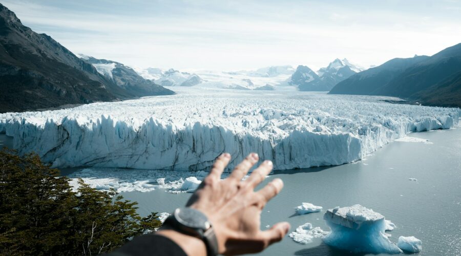 A hand reaching out towards a glacier