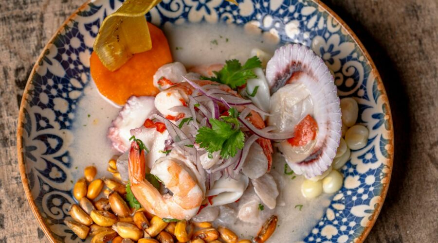 Close-up of vibrant ceviche with seafood, corn, and garnishes.