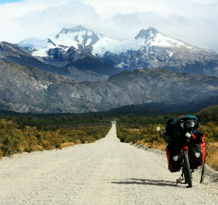 black motorcycle parked at road toward glacier mountain photo during daytime